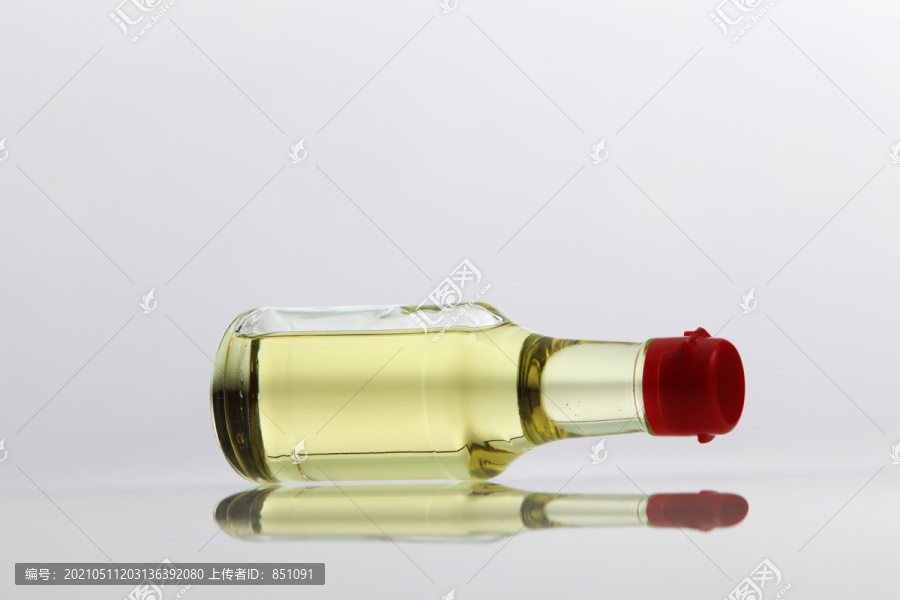 白色背景上的一小瓶食用油