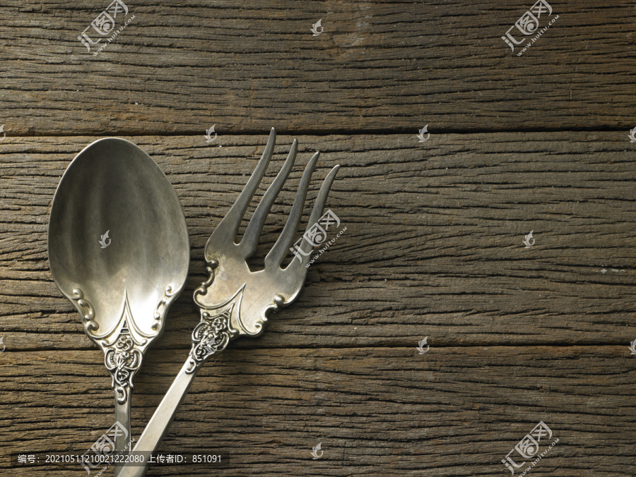 木制背景上的古董叉子和勺子
