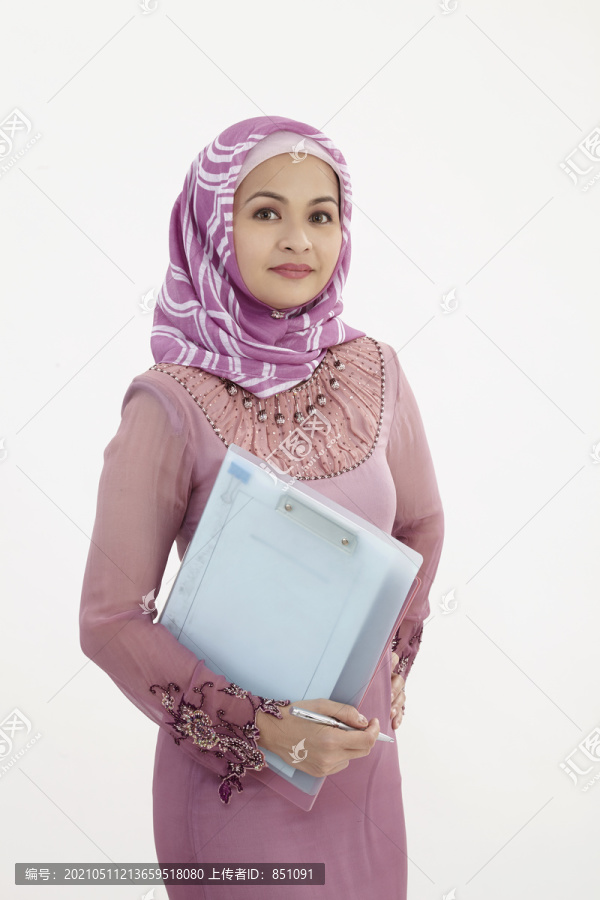 一名马来妇女手持文件，身穿八柱裤