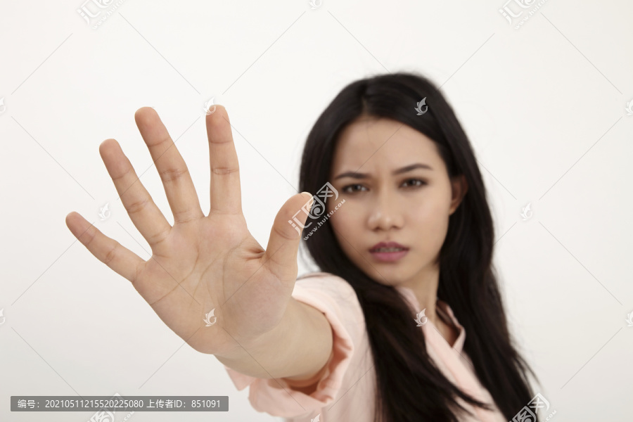 马来妇女在白色背景上做停车标志，注意手掌