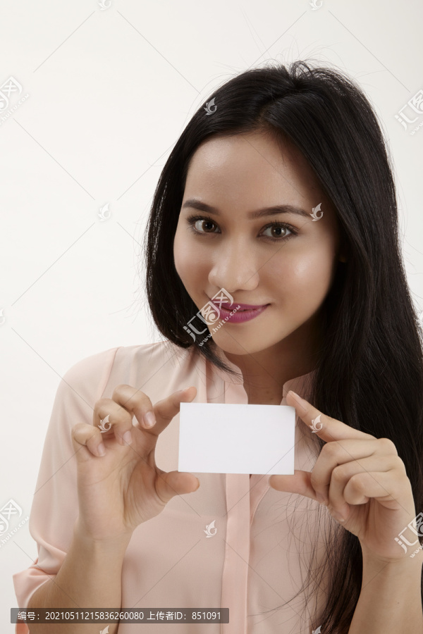 女士出示空白纸牌，并留有文本的复印空间。白色背景下的女模特。