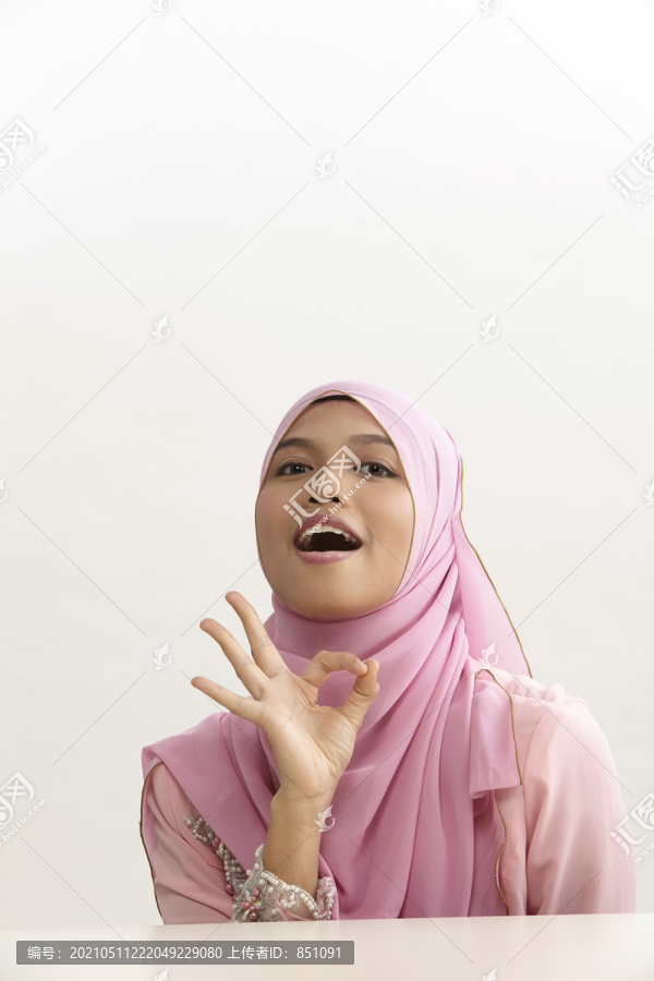 马来妇女手拿图东，手语ok