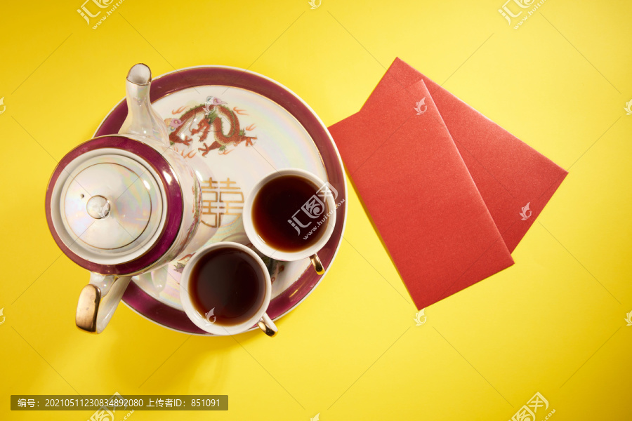 中国传统婚礼上使用的茶壶和茶杯，带有中国标志，寓意幸福。翻译：双喜临门