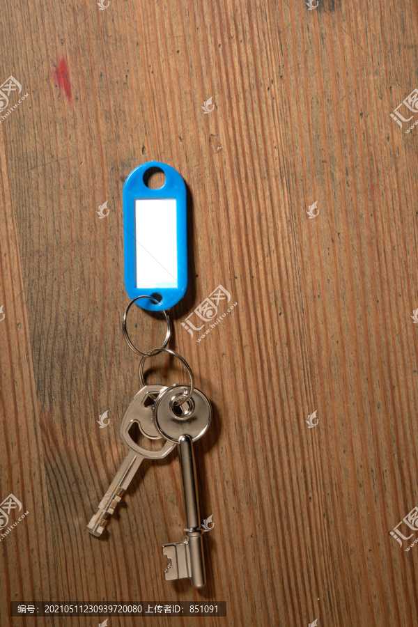 空白标签和一把隔离在木头背景上的钥匙