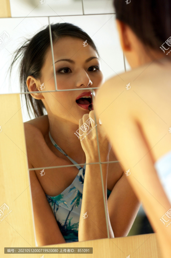 女人嘴唇上涂唇膏的镜像