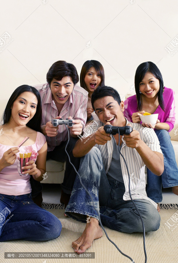 一群男女在家里玩电子游戏机
