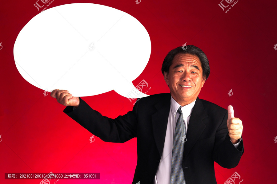 一位老人举着演讲气球竖起大拇指的摄影棚照片
