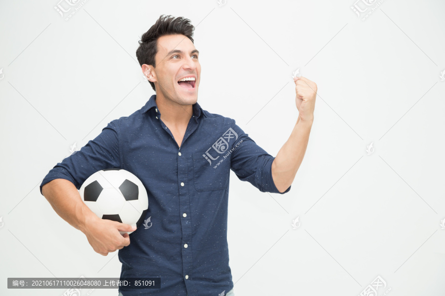 年轻的高加索男子在白色背景下举行足球和庆祝活动，为球迷欢呼和兴奋
