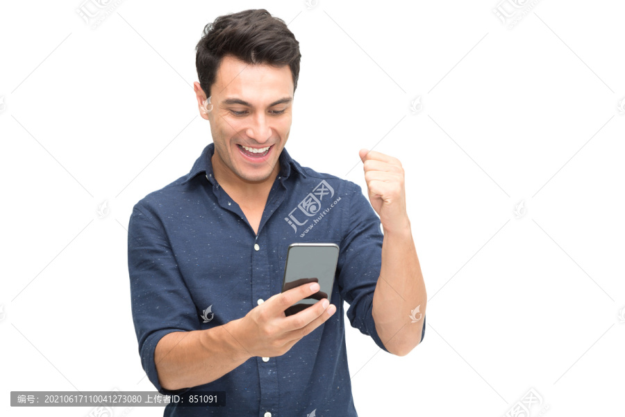 一位兴奋的白人年轻男子的肖像，他一边庆祝一边看着白色背景下的手机