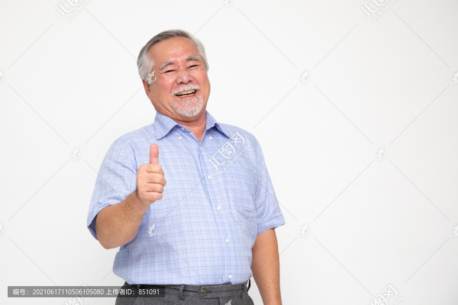 兴高采烈的亚洲老人竖起大拇指，看着隔离在白色背景上的摄像机