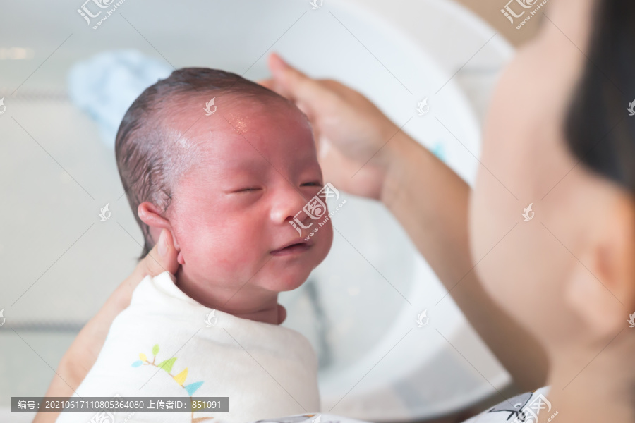 母亲给男婴洗澡洗头