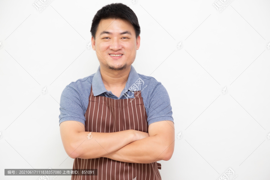 亚洲工人新鲜市场的肖像画，棕色围裙，双臂交叉，白色背景