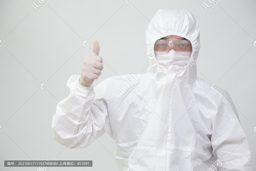 亚洲护士或医生，穿着个人防护装备或PPE套装，自信地向上举手，竖起大拇指
