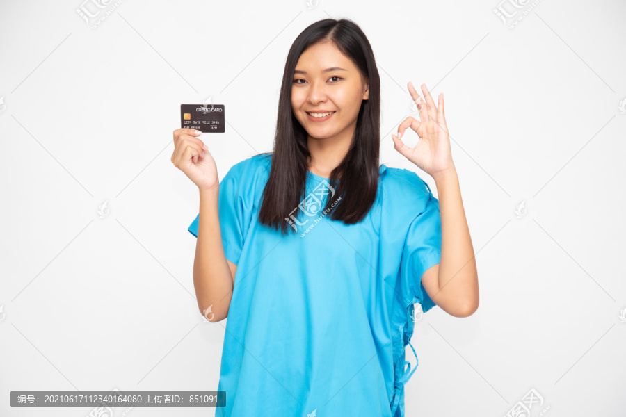 年轻的亚洲美女患者持有个人意外保险信用卡和ok标志，隔离在白色背景上，PA和健康索赔服务理念