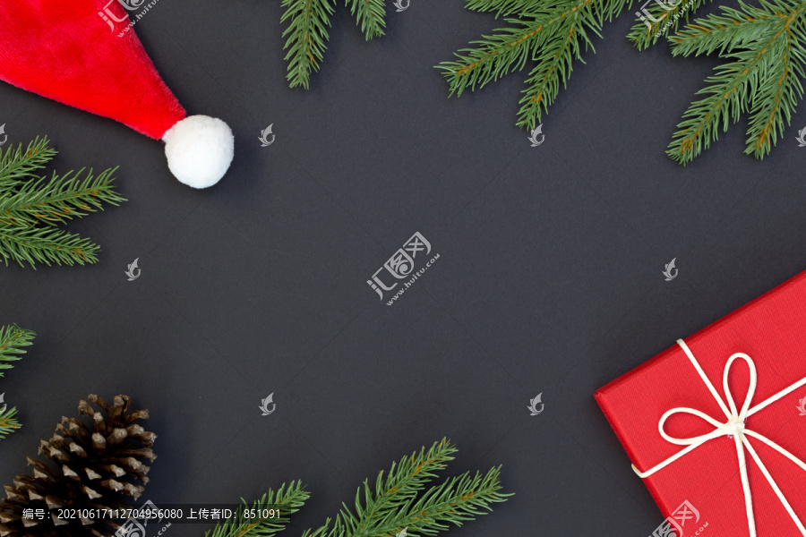 圣诞构图俯视图、礼品盒、松果、黑色背景上的冷杉枝以及文本信息的复制空间
