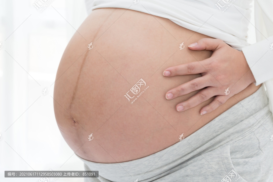 怀抱腹部的孕妇腹部特写