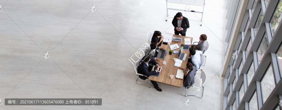 在办公室工作的多民族忙碌人群俯视图，商人和女商人围坐在空白复印空间的会议桌旁的鸟瞰图，商务会议概念