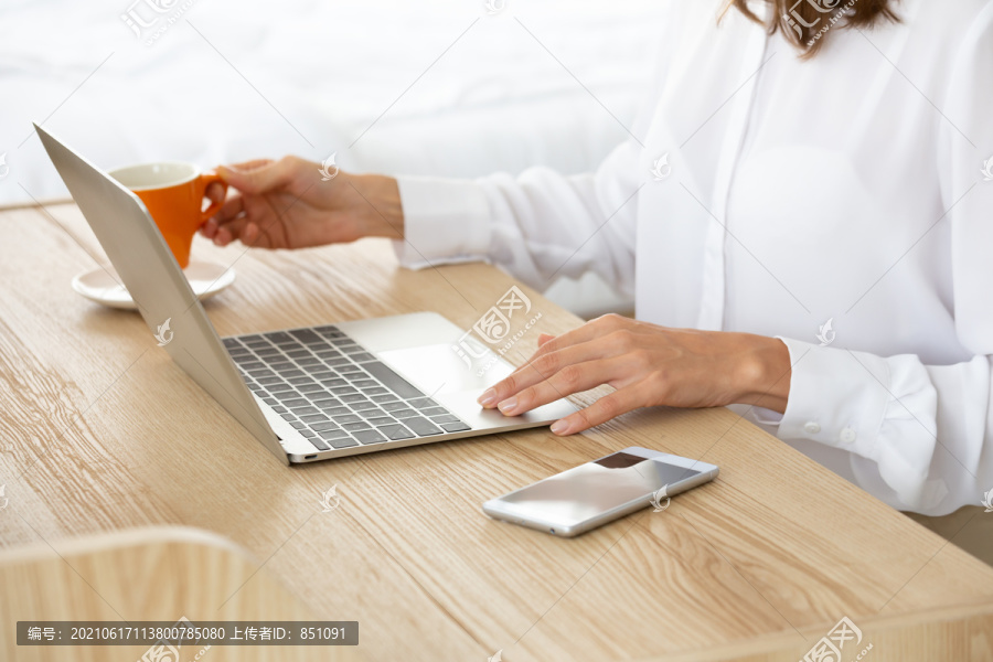女平面设计师在办公室使用笔记本电脑，女商人在工作站的桌上使用笔记本电脑