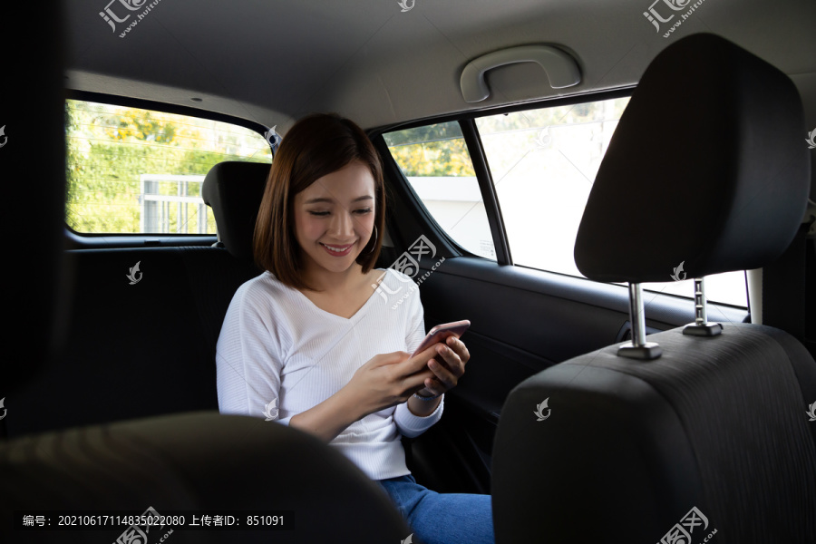 亚洲青少年女性在汽车后座使用智能手机，乘客使用应用程序预订乘车和点对点乘车共享概念