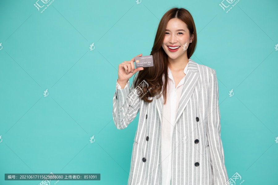 年轻美丽的亚洲女性微笑，展示，出示信用卡进行支付或支付在线业务，支付商户或作为商品、持卡人或持卡人的