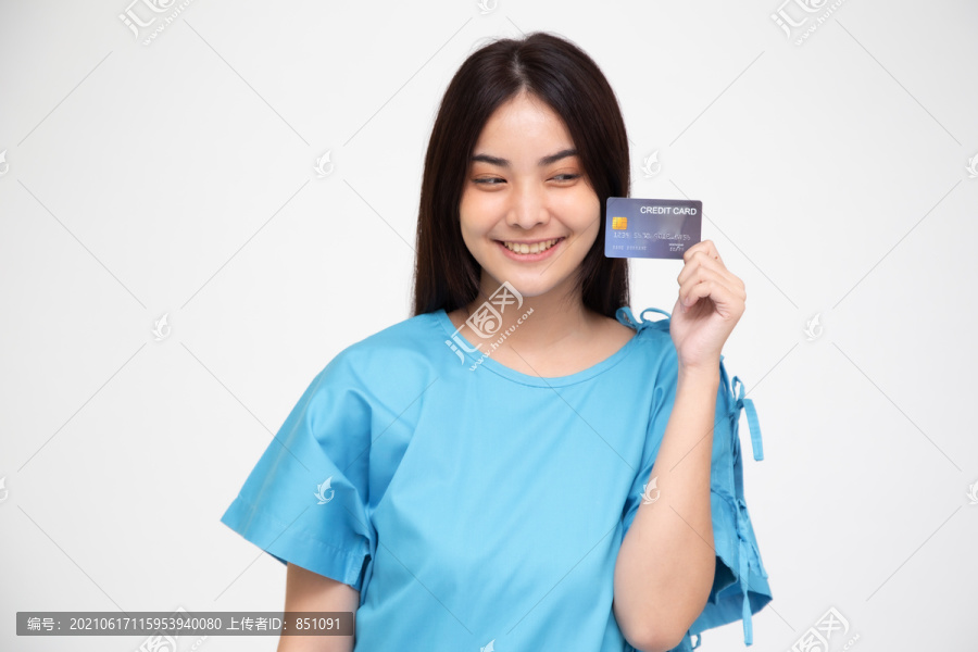 年轻的亚洲美女患者在白色背景上显示信用卡隔离，保险单由银行概念