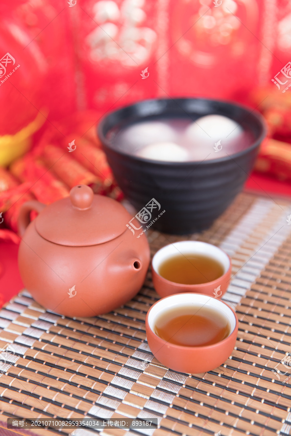 喜庆背景上的一碗汤圆和茶饮