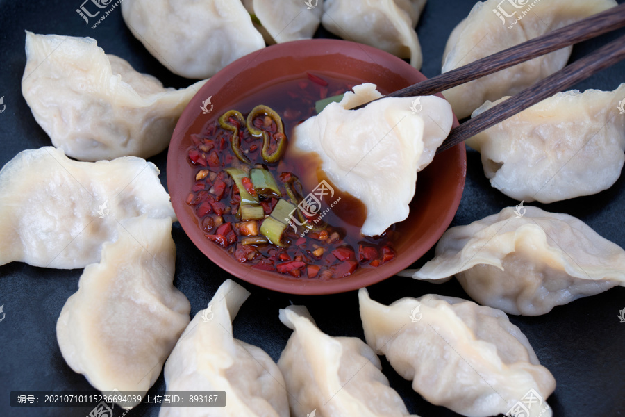 饺子蘸进醋和辣椒调制的蘸料中