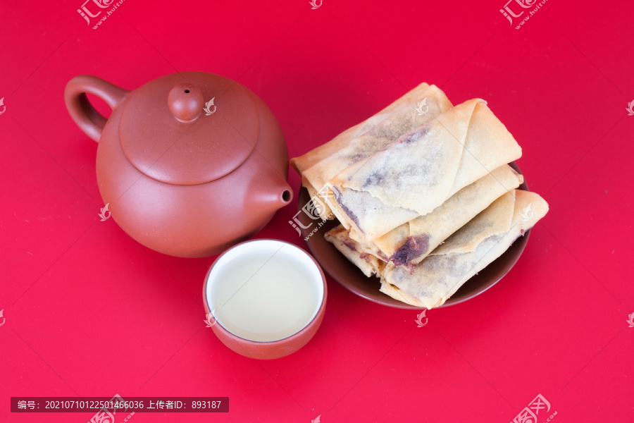 喜庆背景前一盘炸春卷和茶壶茶碗