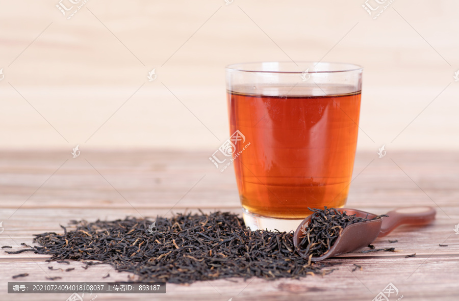 一杯红茶茶水和散落的茶叶