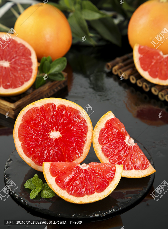 黑石板上放着切开的红心葡萄柚