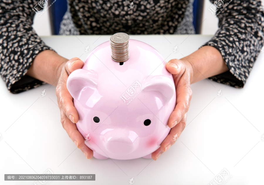 小猪存钱罐和投币口一摞美元硬币