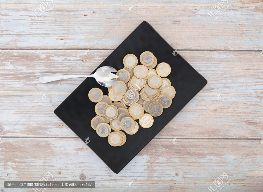 俯视桌子上盛满欧元硬币的盘子