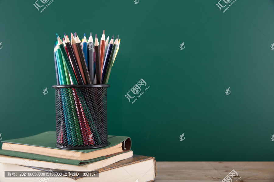 书上一个装满彩铅笔的笔筒