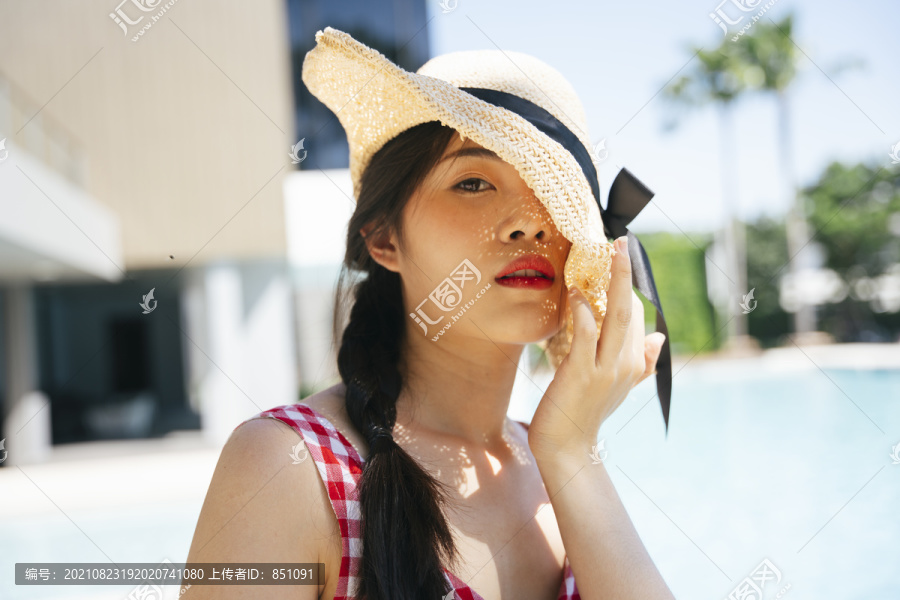 亚洲妇女在度假村和酒店戴帽子的特写肖像。
