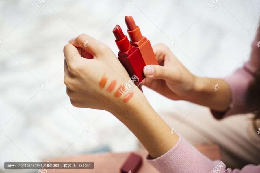 近距离的女性手测试口红颜色比较。