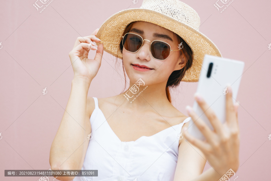 美丽的年轻亚洲女性用智能手机进行视频聊天和直播。