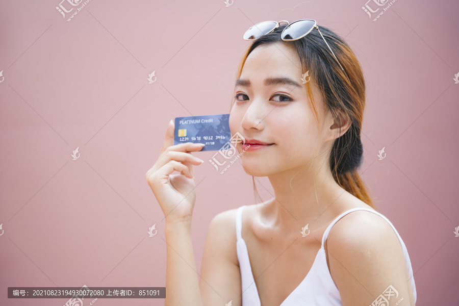 美丽的年轻亚洲女人的肖像，带着信用卡。