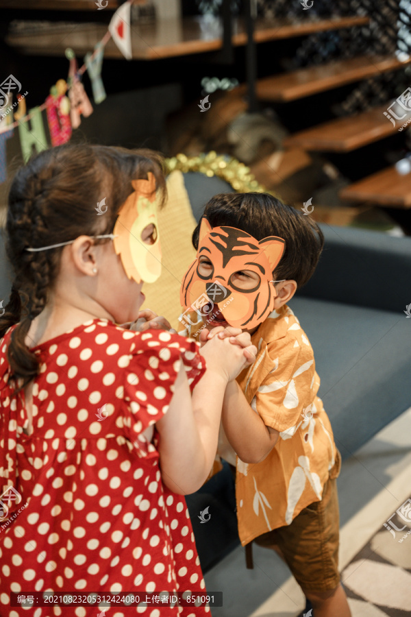 两个小孩戴着动物面具参加万圣节派对。