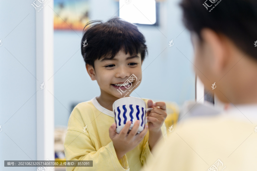 小男孩在镜子前用鲜奶吃早餐。