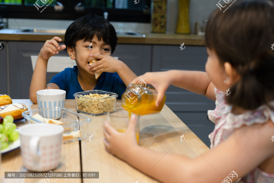 兄弟姐妹上学前在厨房吃早餐。