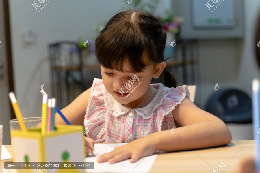 可爱的小女孩认真地看着家做作业。