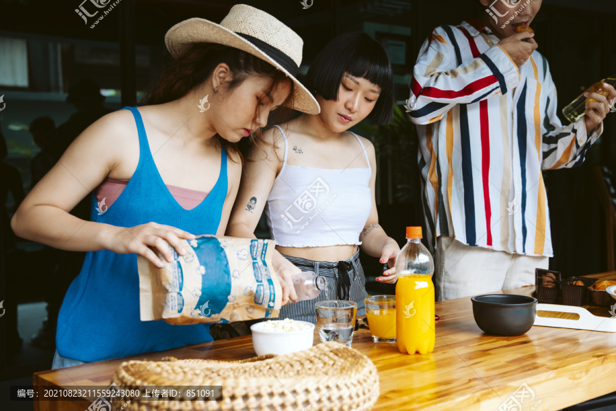 年轻游客在派对开始前准备点心和饮料。