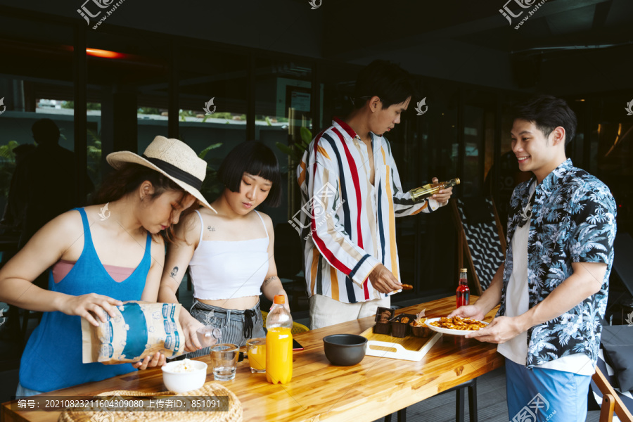 年轻游客在派对开始前准备点心和饮料。