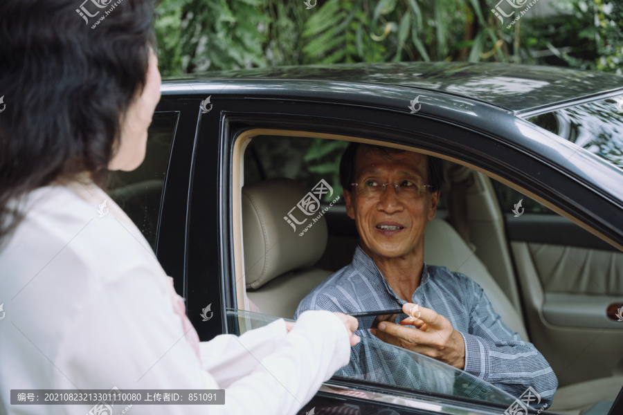 快乐的亚洲前妻在上班前给丈夫智能手机。