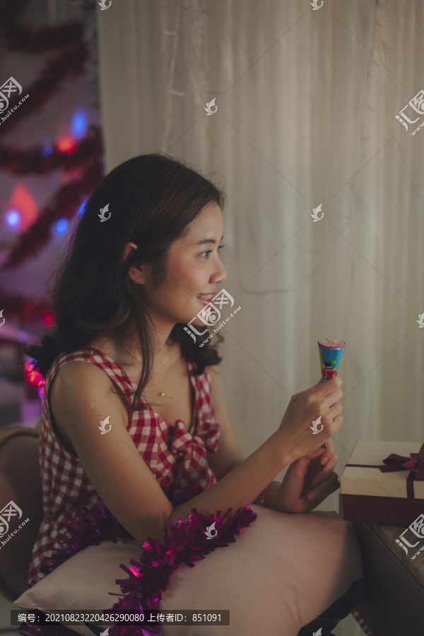 美丽的年轻亚洲女性黑头发用纸片拍摄庆祝圣诞在线派对。