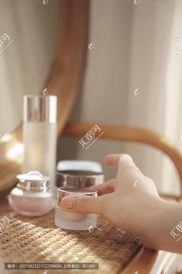 妇女的手拿起或选择木制书桌上的化妆品包装。美容产品模型。