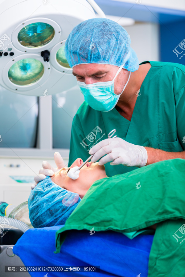 医生外科医生和病人在手术室使用带面罩的麻醉剂