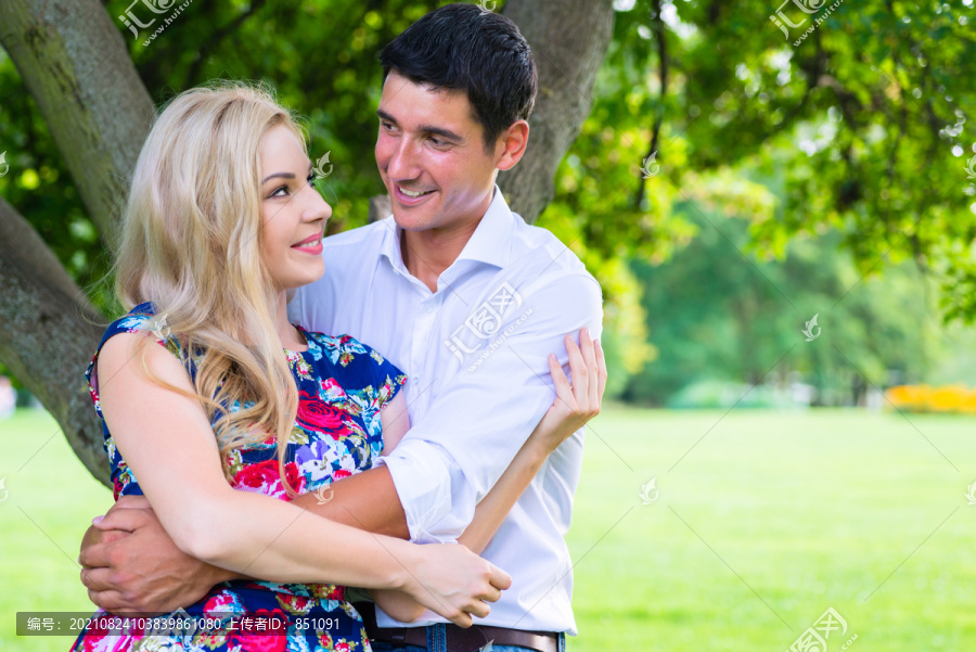 在公园拥抱的男人和女人是相爱的一对