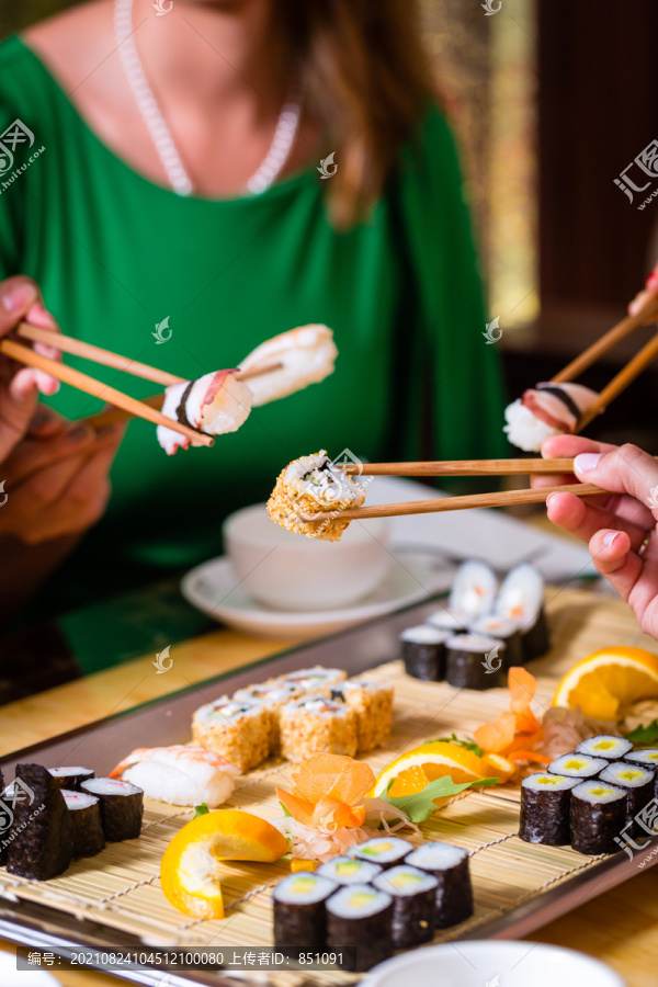 在亚洲餐厅吃寿司的年轻人
