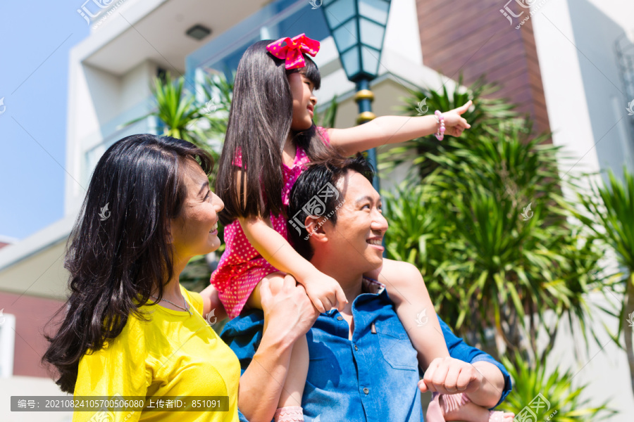 亚洲华人家庭的父母和孩子骄傲地站在现代家庭的前面